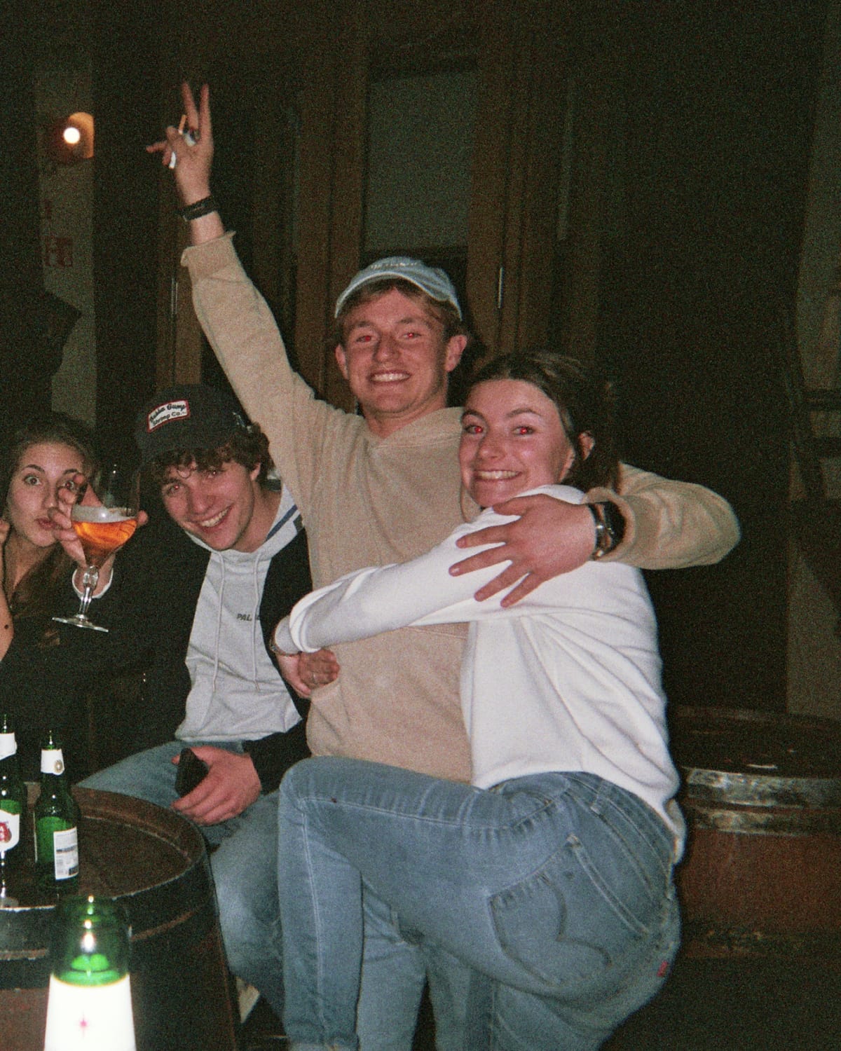 Een groep vrienden klinkt met de armen om elkaar heen aan een tonnetje in De Omgekeerde Wereld.